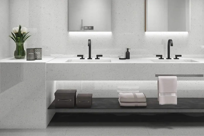 un lavabo de baño en cuarzo Blanco Paloma, grifos negros y accesorios decorativos