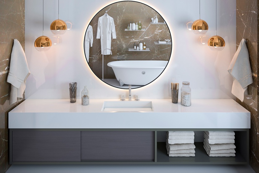 un baño con un lavabo en cuarzo Topzstone Ultra Blanco, un espejo redondo y muebles grises